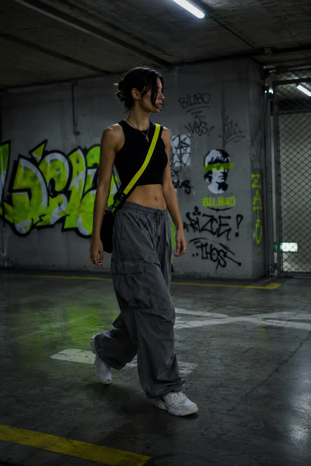 Modelo cruzando un parking caminando con cargo pants HZRD